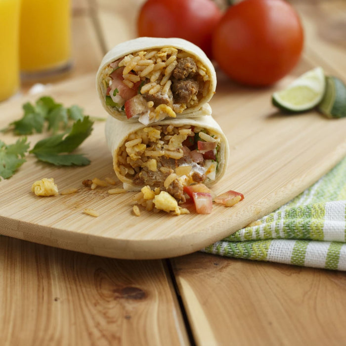 A burrito cut in half and stacked on top of each other, showcasing the filling of rice, meat, and vegetables.