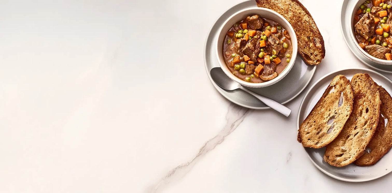 Bowl of soup with bread on a marble surface