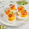 Deviled eggs topped with a carrot curl and microgreens.