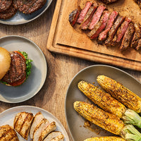 mutliple grilled dishes on a wooden table