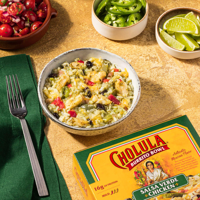 A bowl of Cholula Salsa Verde Chicken Burrito Bowl with a fork and other ingredients on the side.