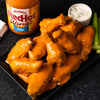 A plate of Franks RedHot Wings with a side of blue cheese dressing and celery.