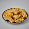 A plate of toasted garlic bread with herbs.