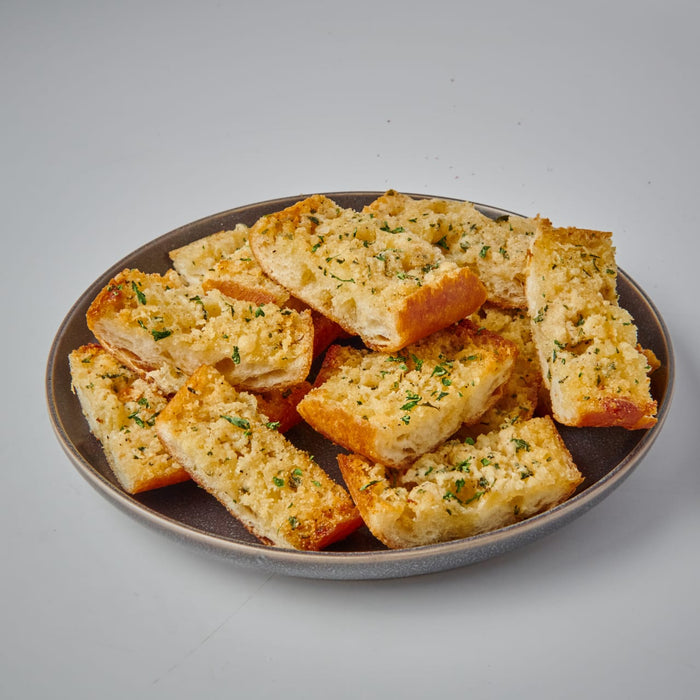 A plate of toasted garlic bread with herbs.