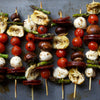 Grilled skewers with artichoke, mozzarella, cherry tomatoes, asparagus, and mushrooms.