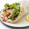 A close-up of a chicken gyro with lettuce, tomato, onion, and tzatziki sauce.