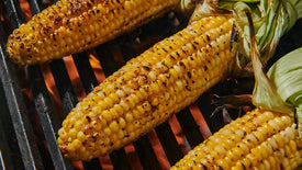 grilled corn on the grill with the cob pulled back