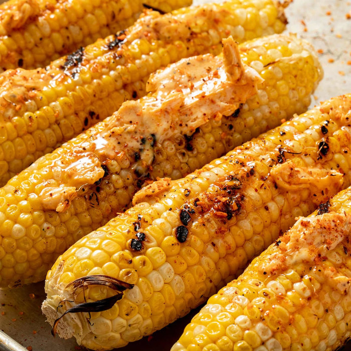 Grilled corn on the cob with butter and spices.