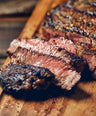 close up of a grilled steak on wooden plate