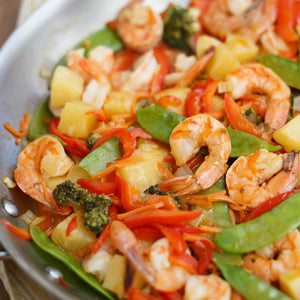 A close-up of a pan of shrimp stir fry with vegetables.