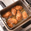 A deep fryer with chicken pieces frying in hot oil.