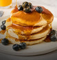 Stack of pancakes with syrup and blueberries