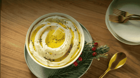 Bowl of mashed potatoes with a decorative touch on a wooden table