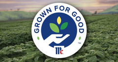 Grown for Good logo with a hand holding leaves, shown over a field of green plants at sunset.