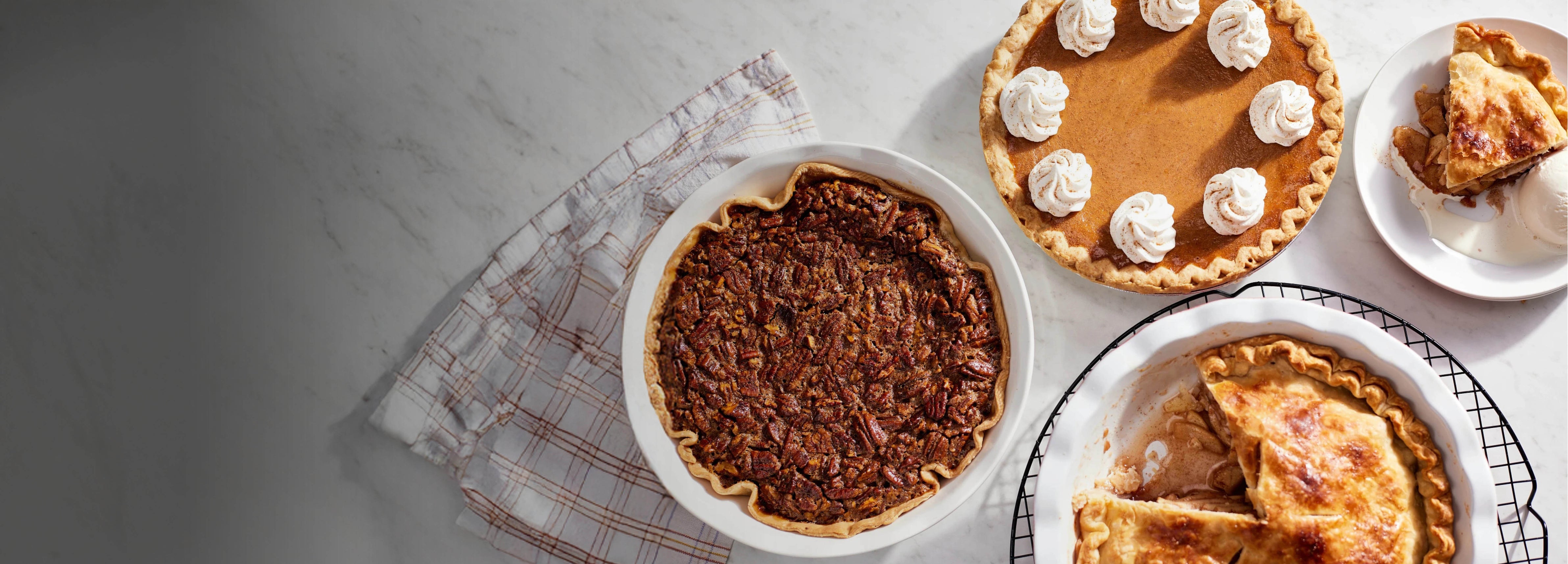 Three pies on a table with a white background.