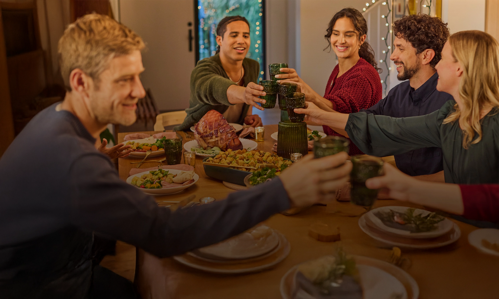 Group of people enjoying a meal together at a table with drinks and food.