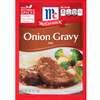 McCormick Onion Gravy Mix packet with a dish of meatloaf and vegetables on a white background