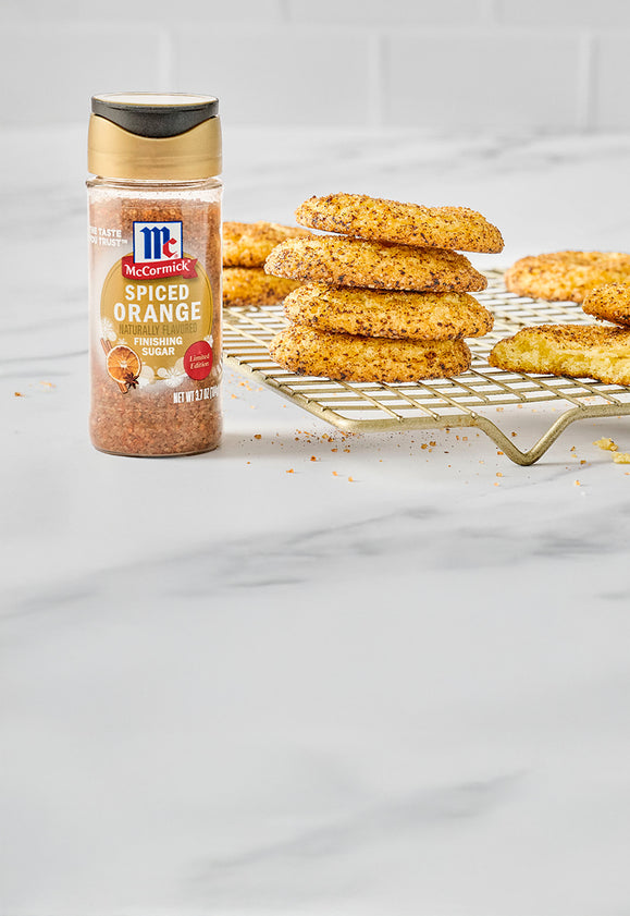 McCormick Spiced Orange Finishing Sugar next to a stack of spiced cookies cooling on a wire rack