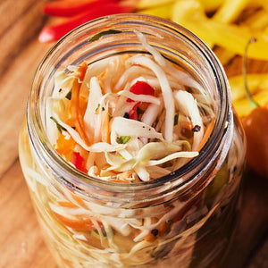 A glass jar filled with a colorful coleslaw.