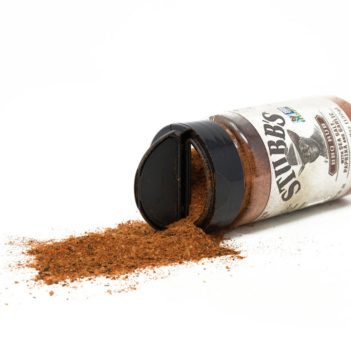 A bottle of Stibbs BBQ Rub with the lid open and the seasoning spilling out.