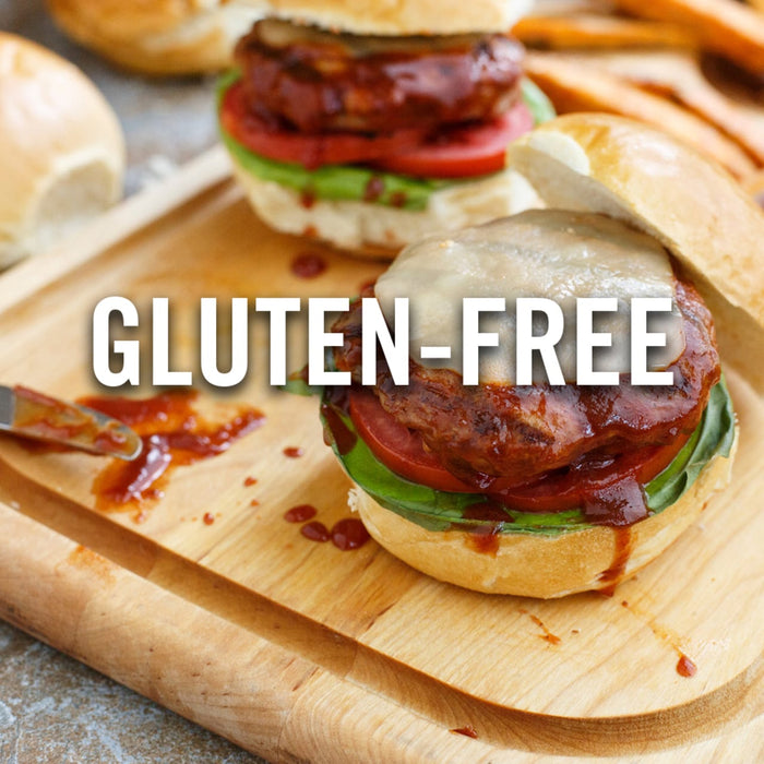 A close-up of a gluten-free burger on a wooden cutting board.