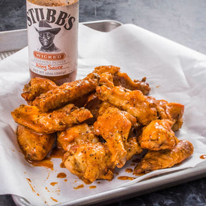 A plate of chicken wings covered in Stubbs Wicked Habanero Pepper Wing Sauce.