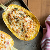 A close-up of a baked spaghetti squash with melted cheese on top.
