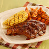 A plate of barbecue ribs, corn on the cob, and sweet potato fries.