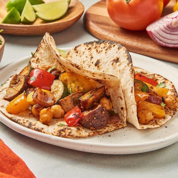 Two tortillas filled with roasted vegetables and chickpeas.