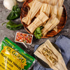 A package of El Guayo corn husks for tamales, along with a plate of tamales, salsa, onions, and peppers.
