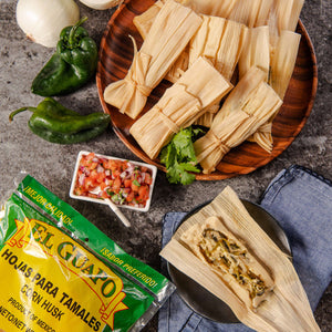 A package of El Guayo corn husks for tamales, along with a plate of tamales, salsa, onions, and peppers.
