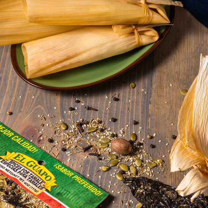 A package of El Guapo spices for tamales, along with dried corn husks and spices.