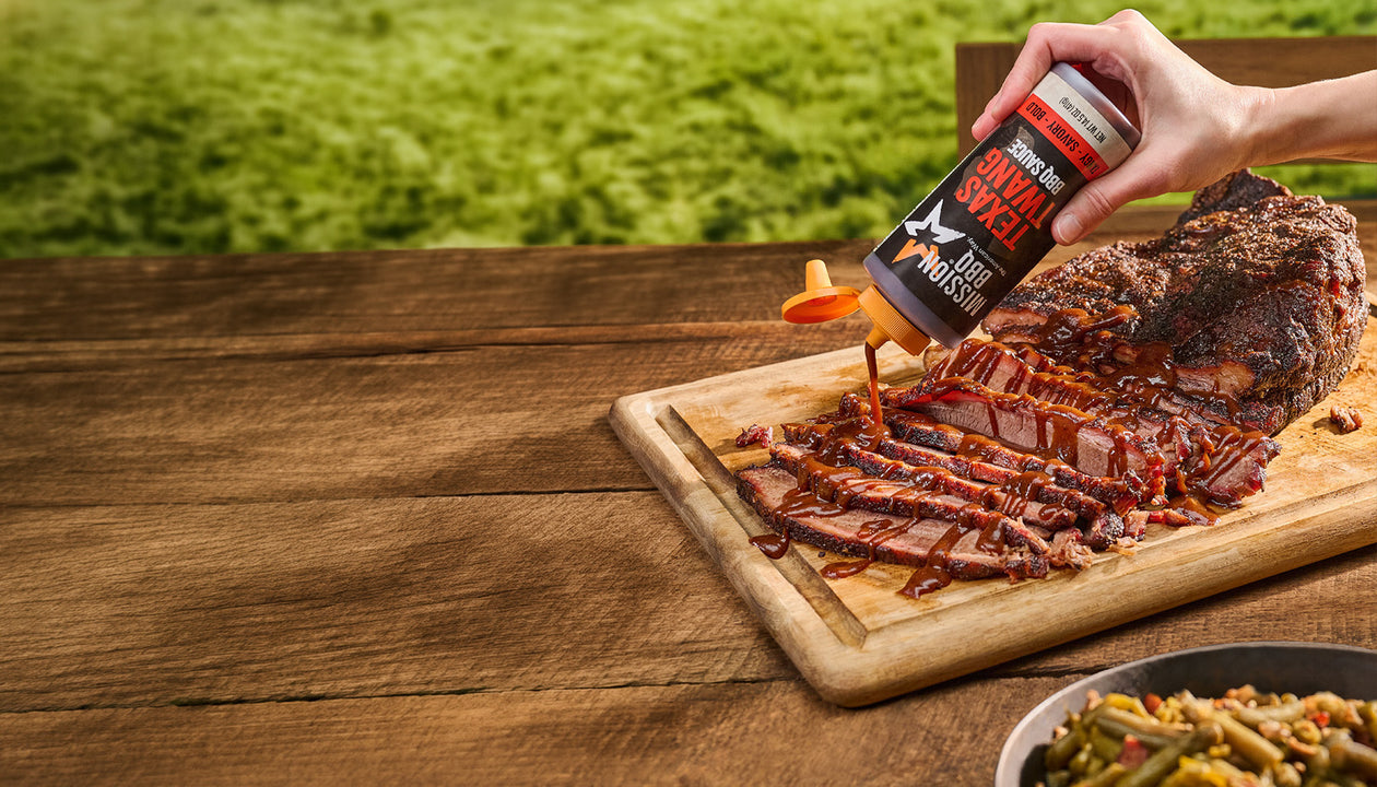 Drizzling texas twang sauce on a brisket