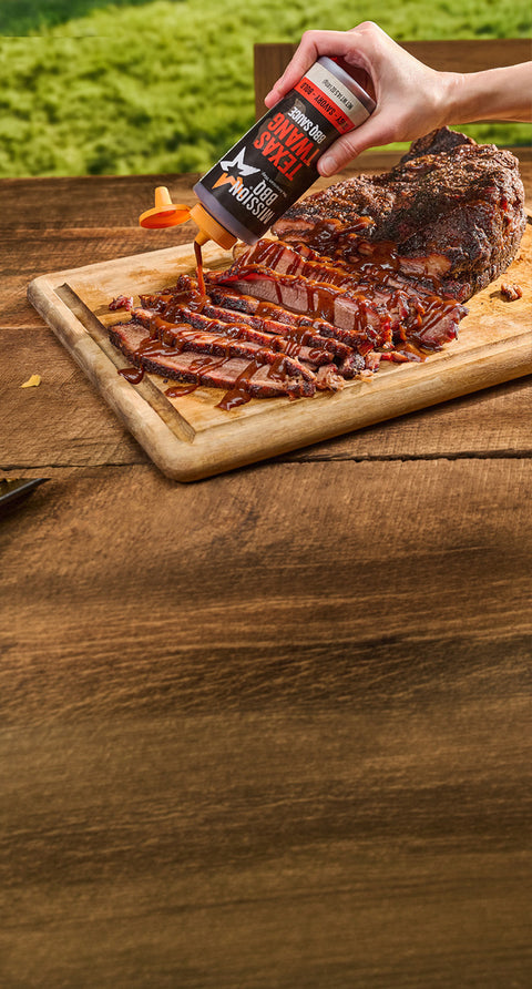 Drizzling texas twang sauce on a brisket