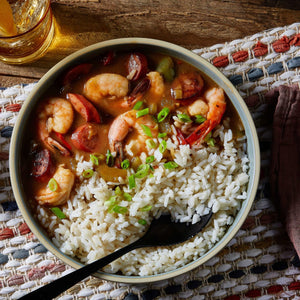 A bowl of shrimp and sausage gumbo with white rice.