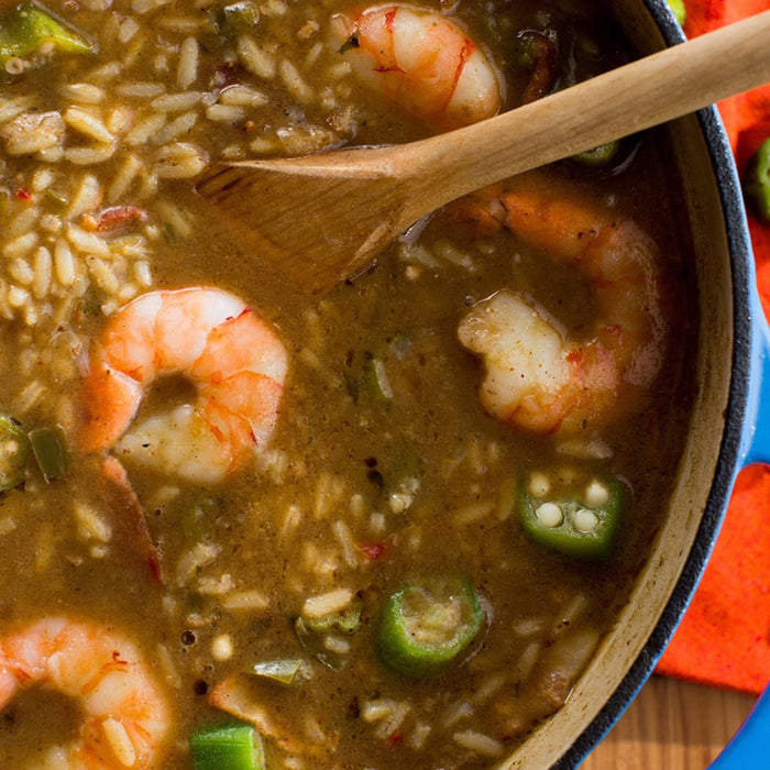 A close-up of a pot of gumbo with shrimp, rice, and okra.
