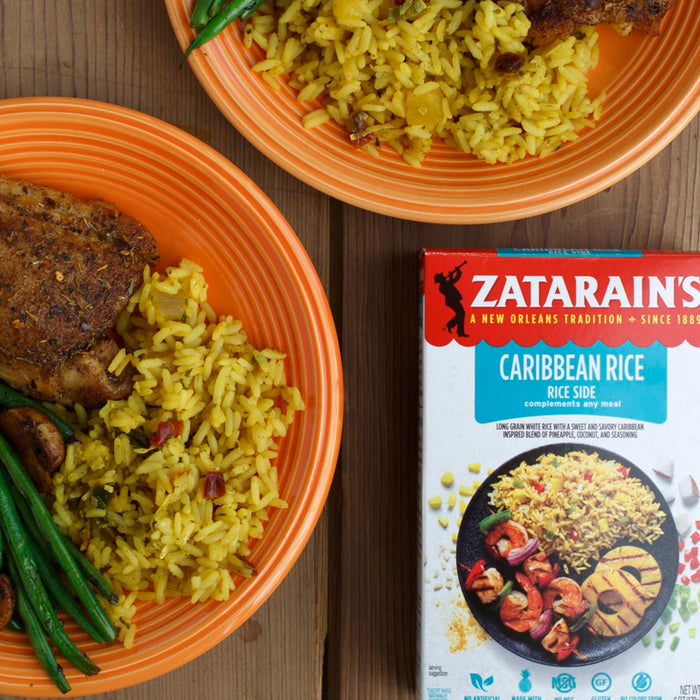 A box of Zatarains Caribbean Rice next to a plate of rice and chicken.